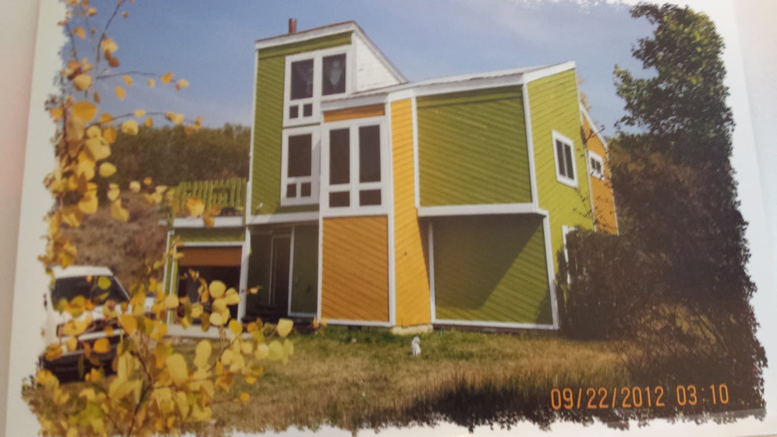 Scanned 2012 print of the house, painted green and yellow, among autumn aspens