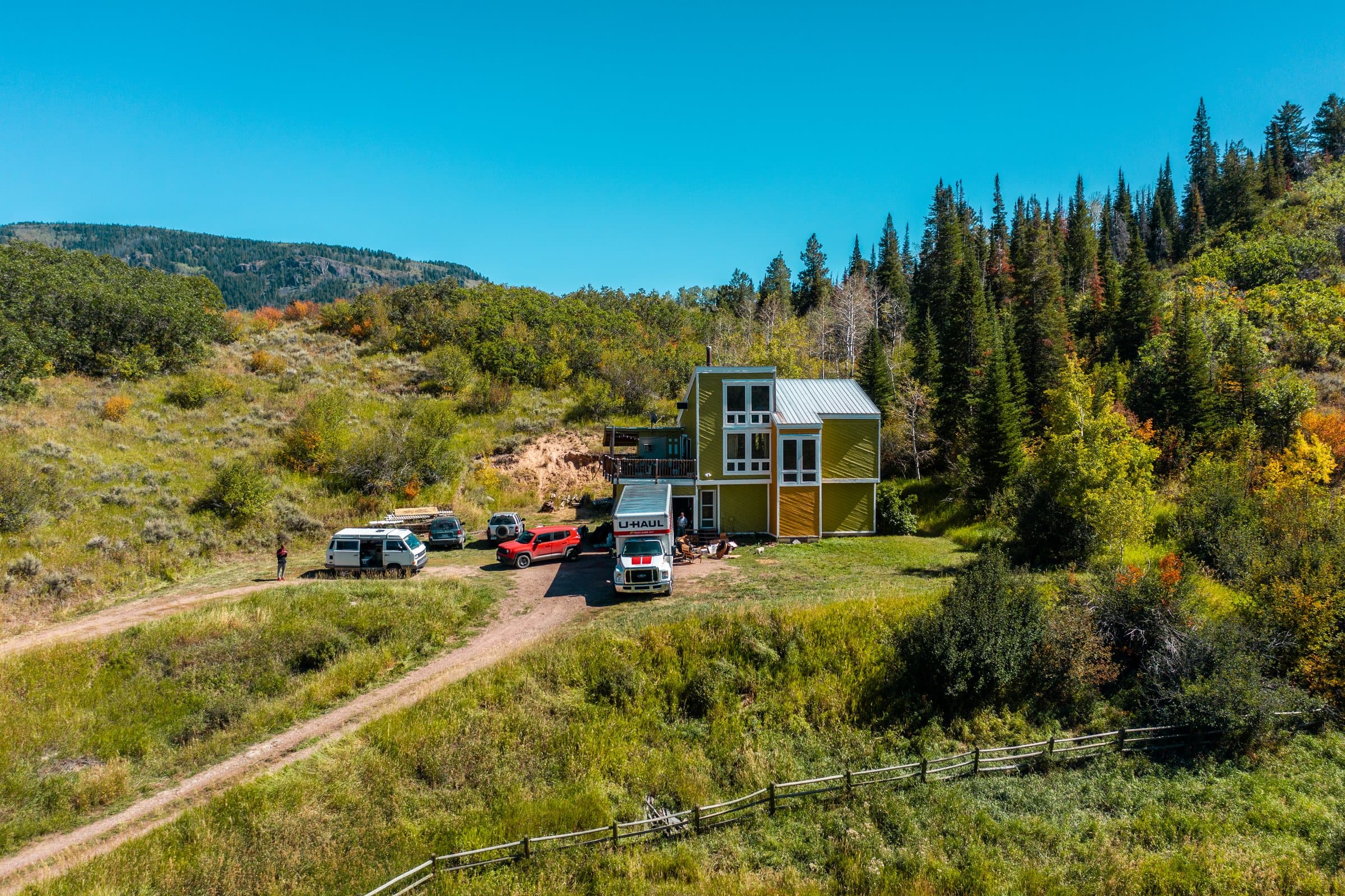 2019 drone photo of the house with its driveway, meadow and forested hillside
